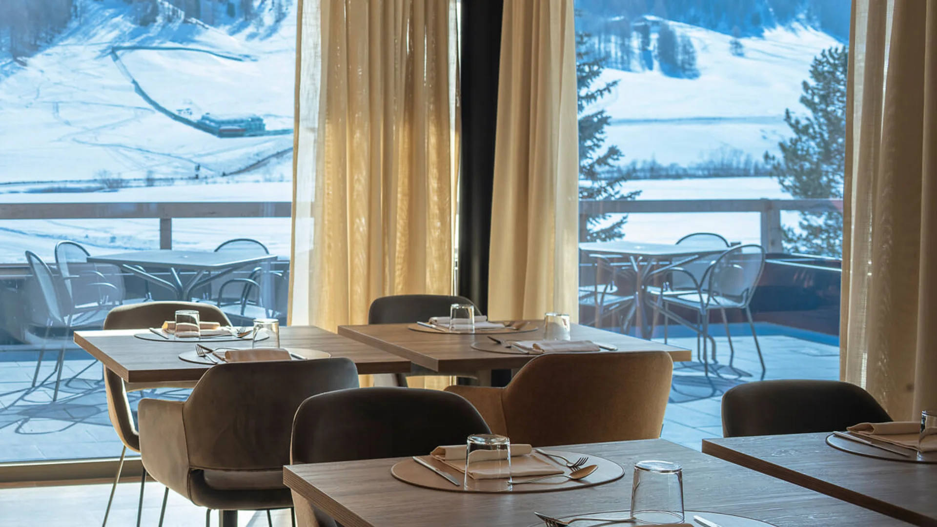 Restaurant with set tables and snowy mountain view