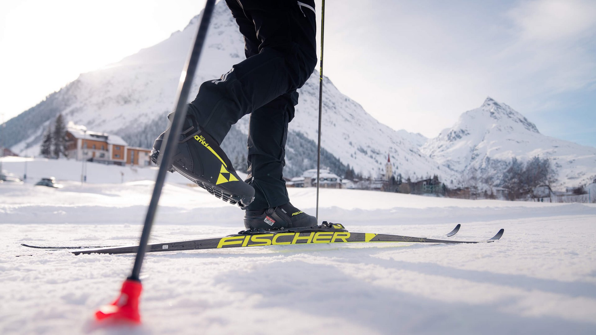 Person beim Langlaufen auf verschneiter Berglandschaft mit Skiern und Stöcken