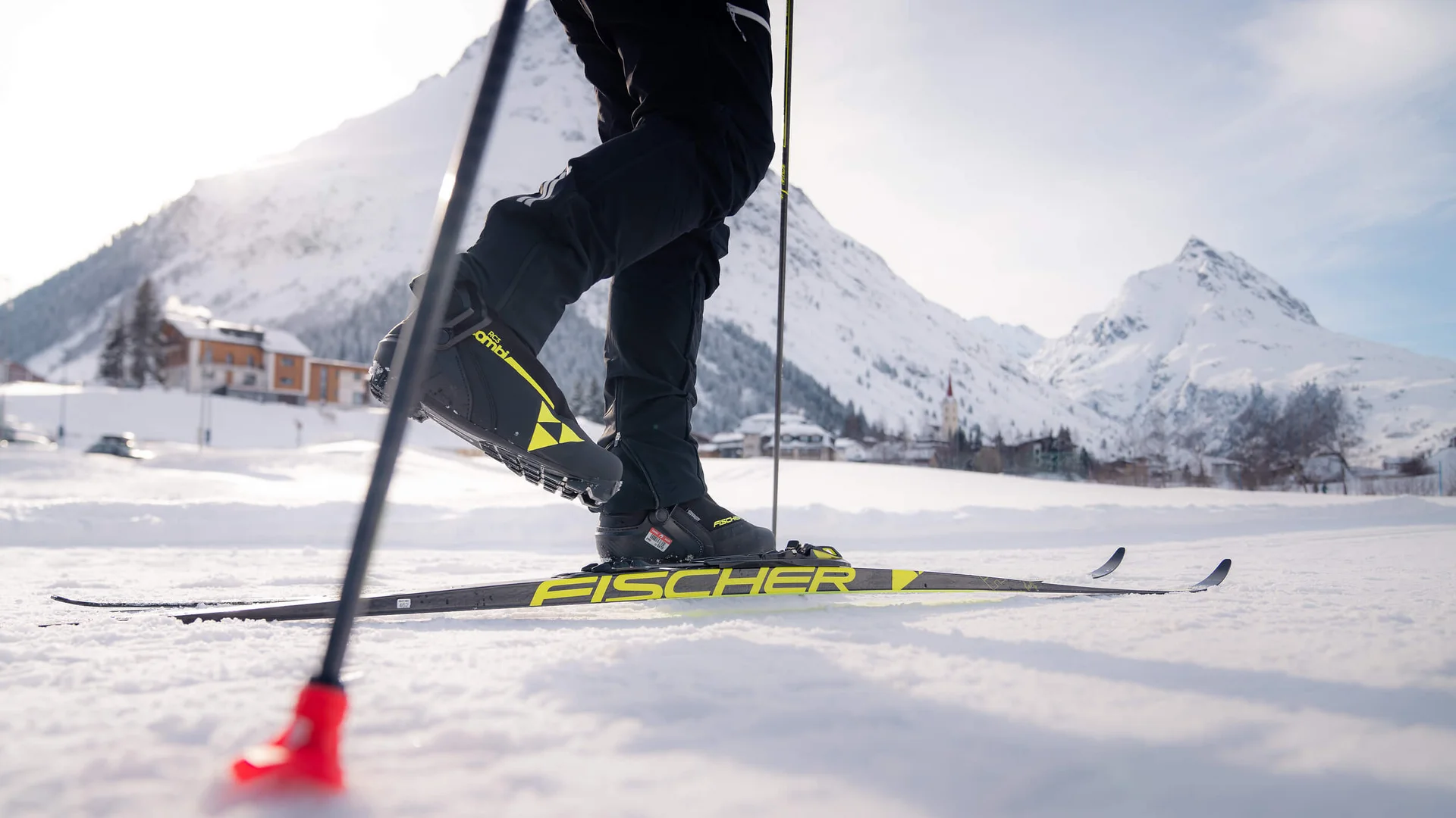 Person beim Langlaufen auf verschneiter Berglandschaft mit Skiern und Stöcken