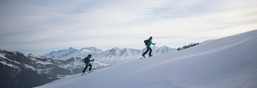 Ratschings © Ratschings Tourismus - Manuel Kottersteger Zwei Skifahrer steigen auf schneebedecktem Berg mit Alpen im Hintergrund auf