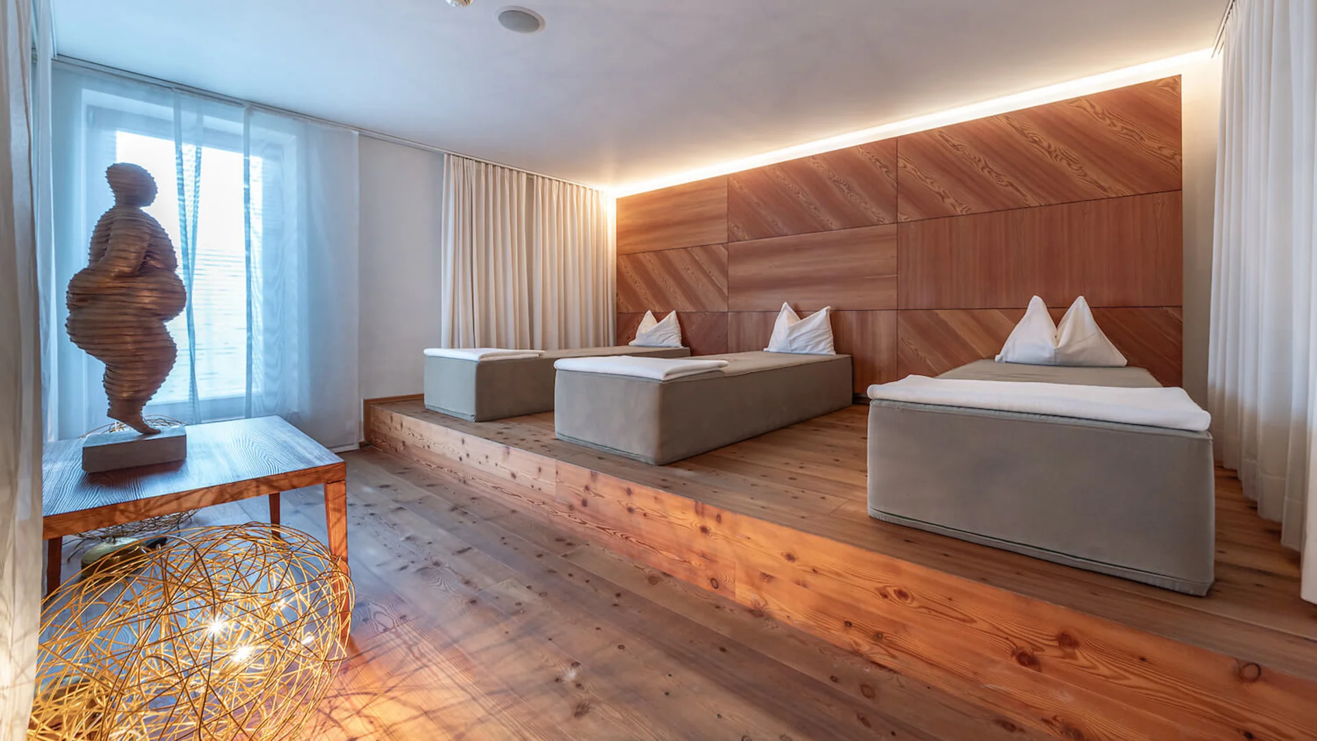 Modern eingerichteter Ruheraum mit drei Liegen und Holzdekor