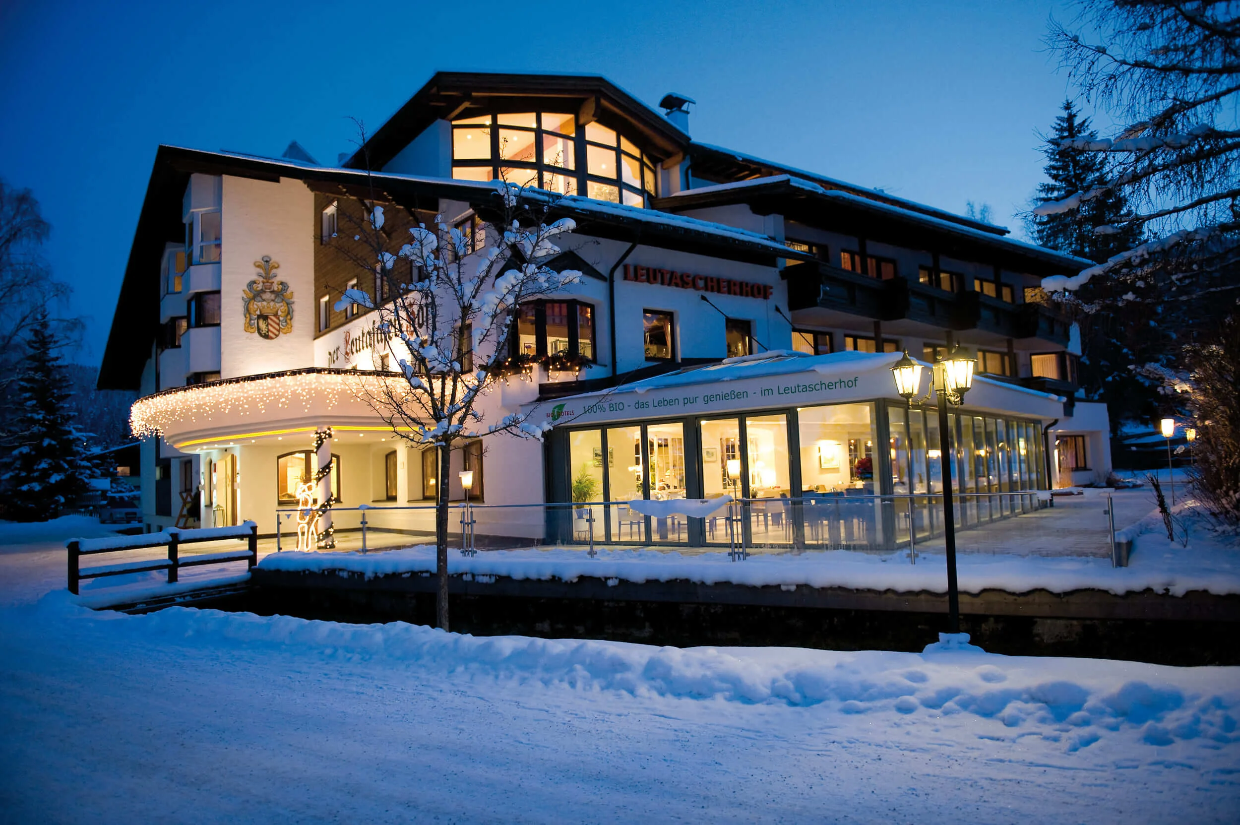 Leutascherhof hotel in winter with snow and lights at dusk
