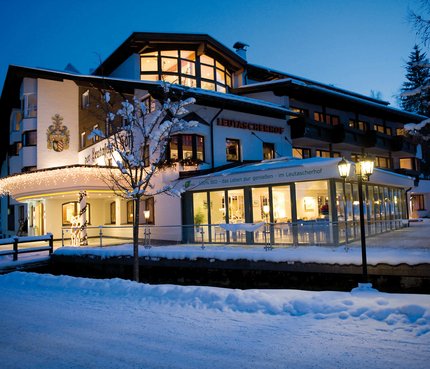 Leutascherhof hotel in winter with snow and lights at dusk