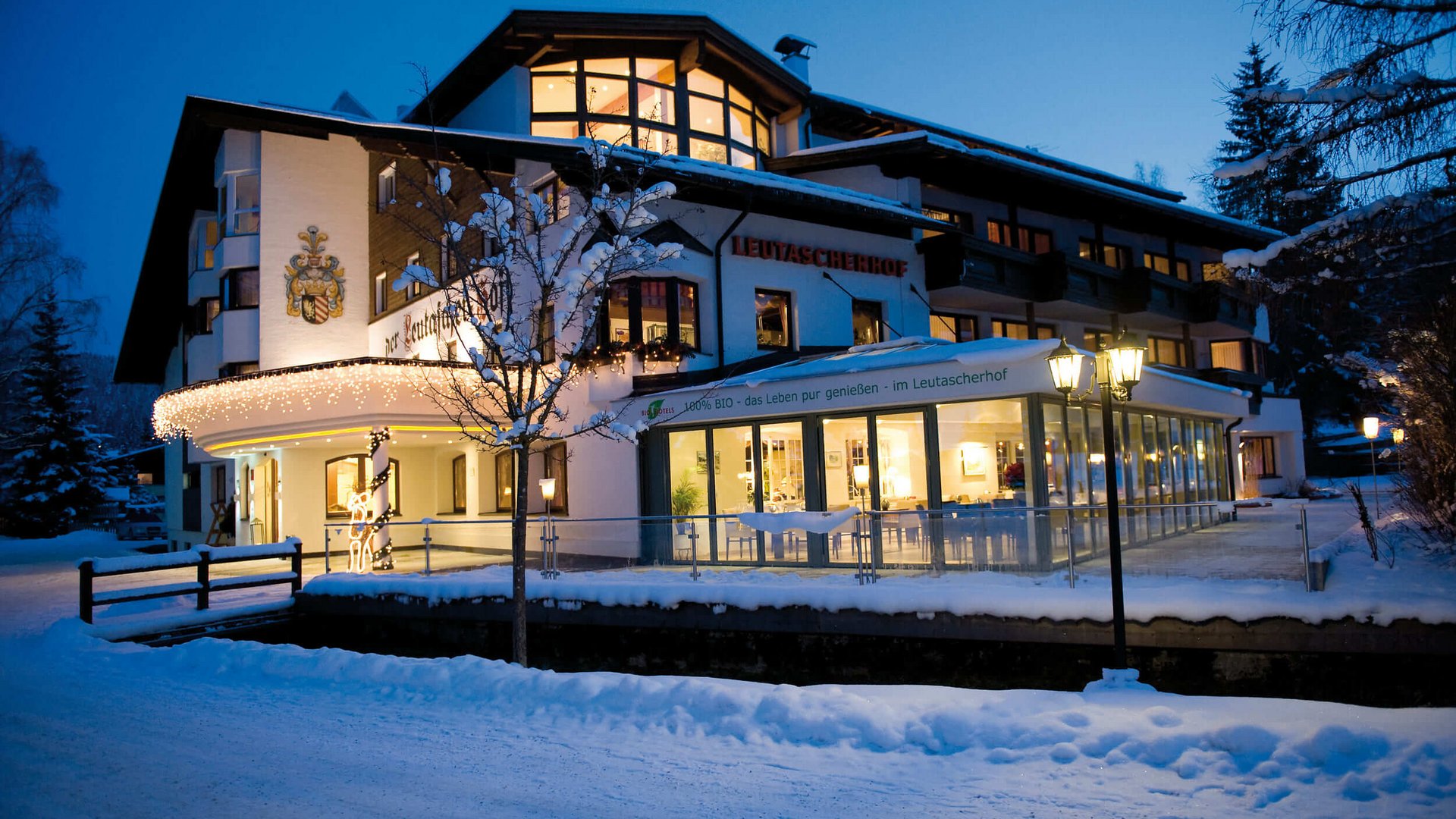 Leutascherhof hotel in winter with snow and lights at dusk