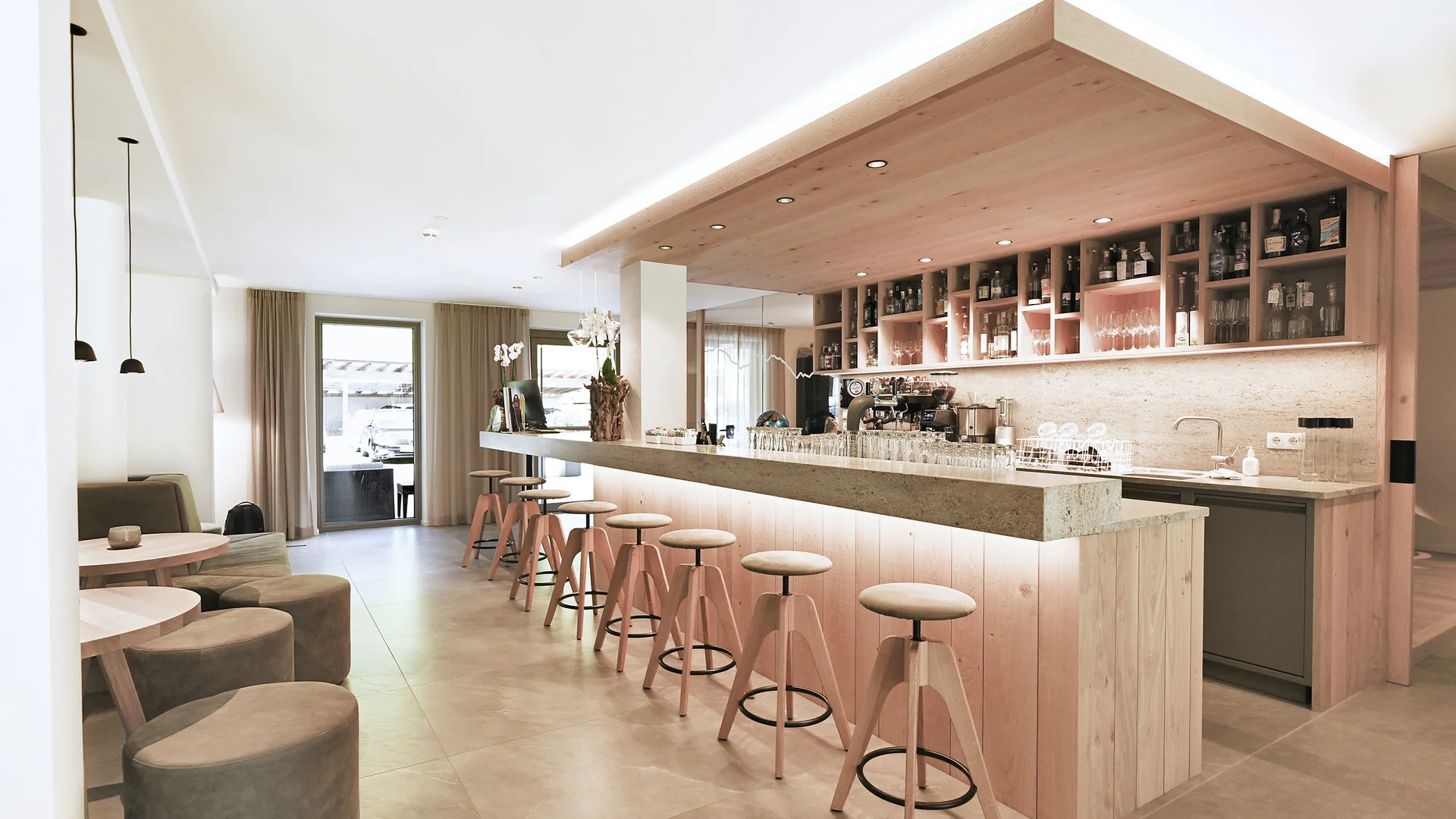 Hotel Vierbrunnenhof ***S © Justina Zdanoviciute Moderner heller Barbereich mit Holzstühlen und Sitzgelegenheiten