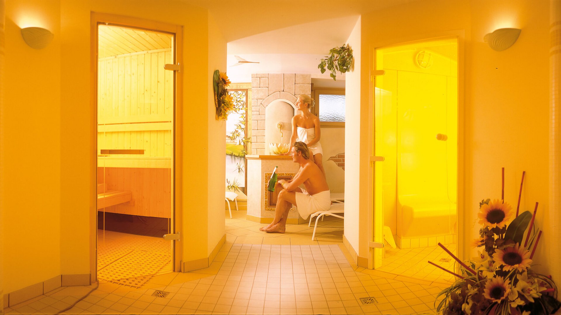 Couple relaxing in a sauna and wellness area with wooden interior