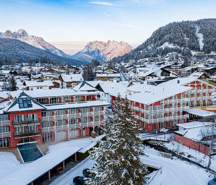 Snow-covered village with houses and mountains in the background