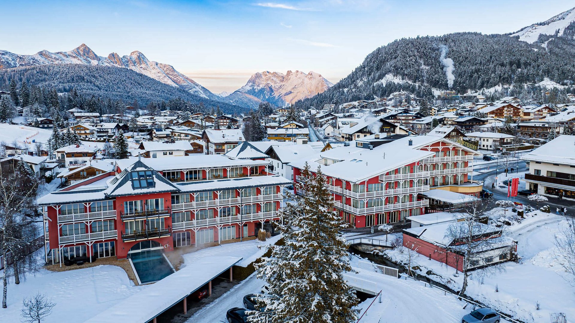 Snow-covered village with houses and mountains in the background