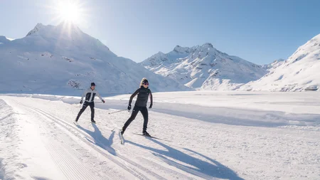 Schneesicher langlaufen: Wo Snowfarming in Österreich frühen Saisonstart möglich macht
© TVB Paznaun-Ischgl Zwei Personen beim Langlaufen in verschneiter Berglandschaft bei Sonnenschein