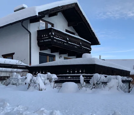 Schneebedecktes Haus und Garten bei klarem Himmel
