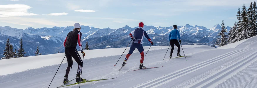 Bauernhof Krahlehen © Coen Weesjes Three cross-country skiers on snowy mountain trail with alpine background