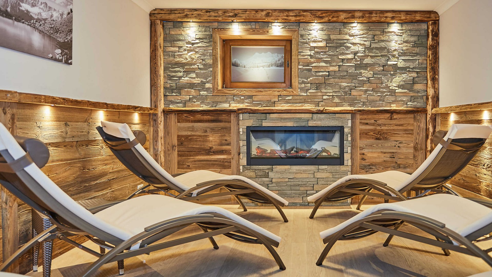 Relaxation area with lounge chairs in front of fireplace and stone wall