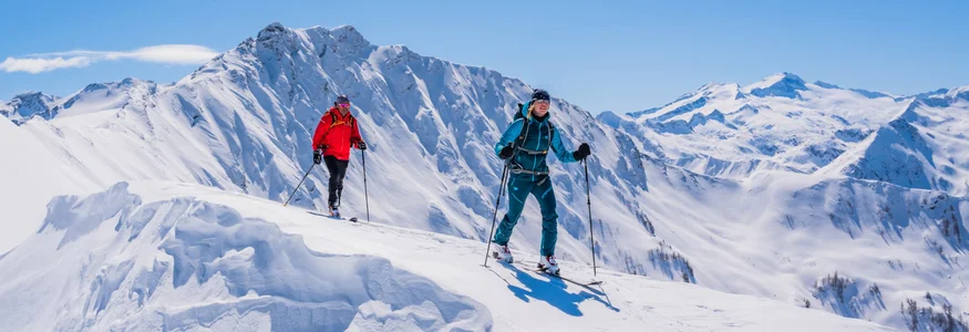 Bauerndörfl Rindereben © TVB Großarltal / Peter Maier Two skiers hiking on a snowy mountain ridge under a clear blue sky