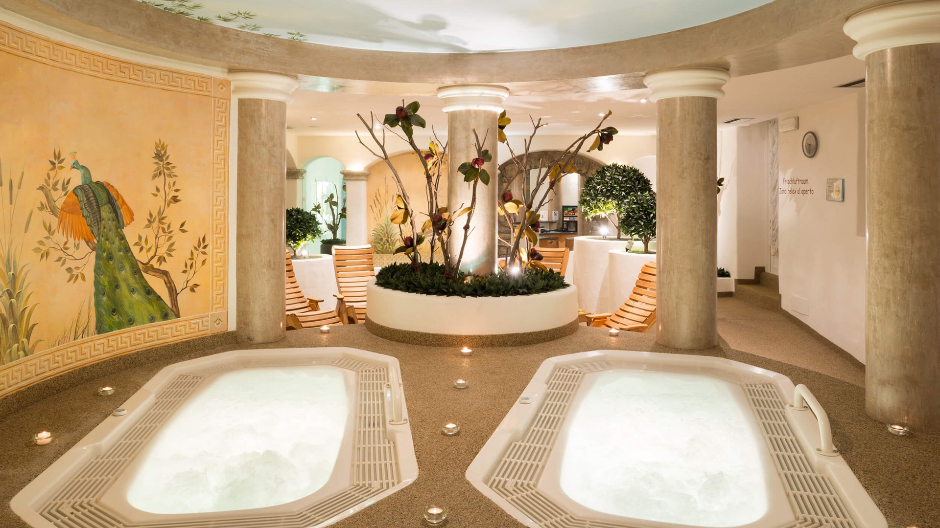 Innenraum mit zwei Whirlpoolbecken, Säulen und Wandmalerei eines Pfaues