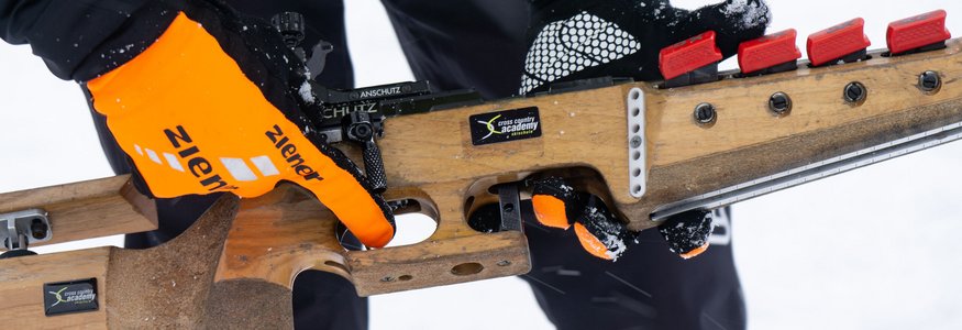How to Hobbybiathlon
© Region Seefeld Person hält Biathlon-Gewehr mit orangenen Handschuhen im Schnee