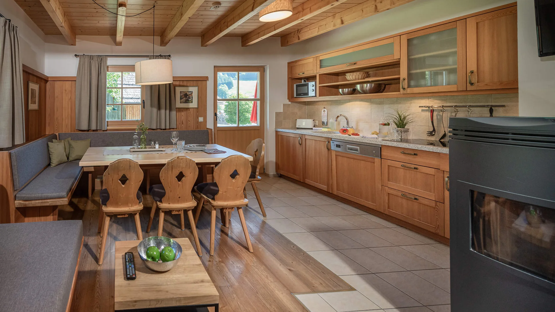 Cozy kitchen with wooden ceiling and dining area with table and chairs