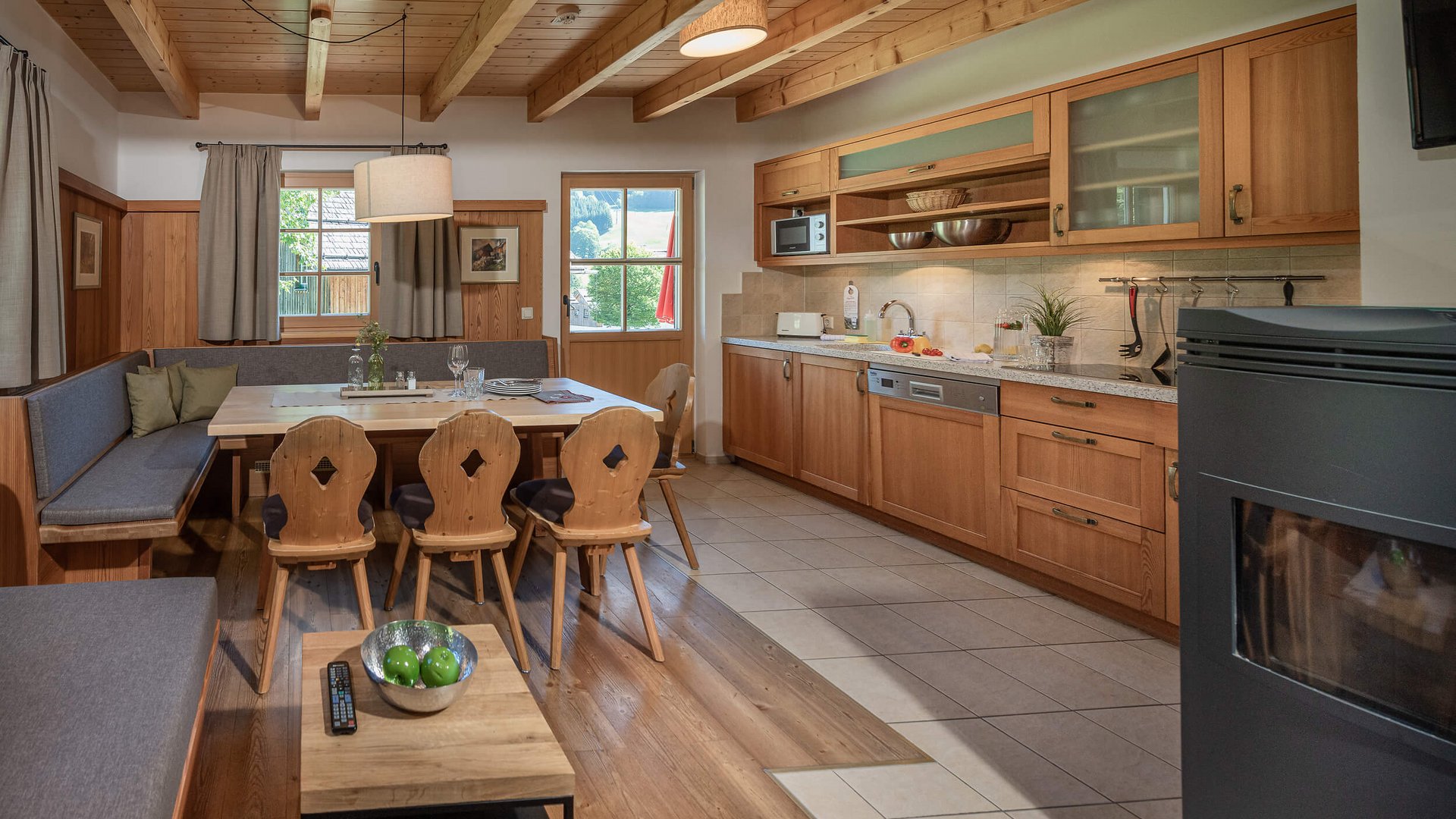 Cozy kitchen with wooden ceiling and dining area with table and chairs