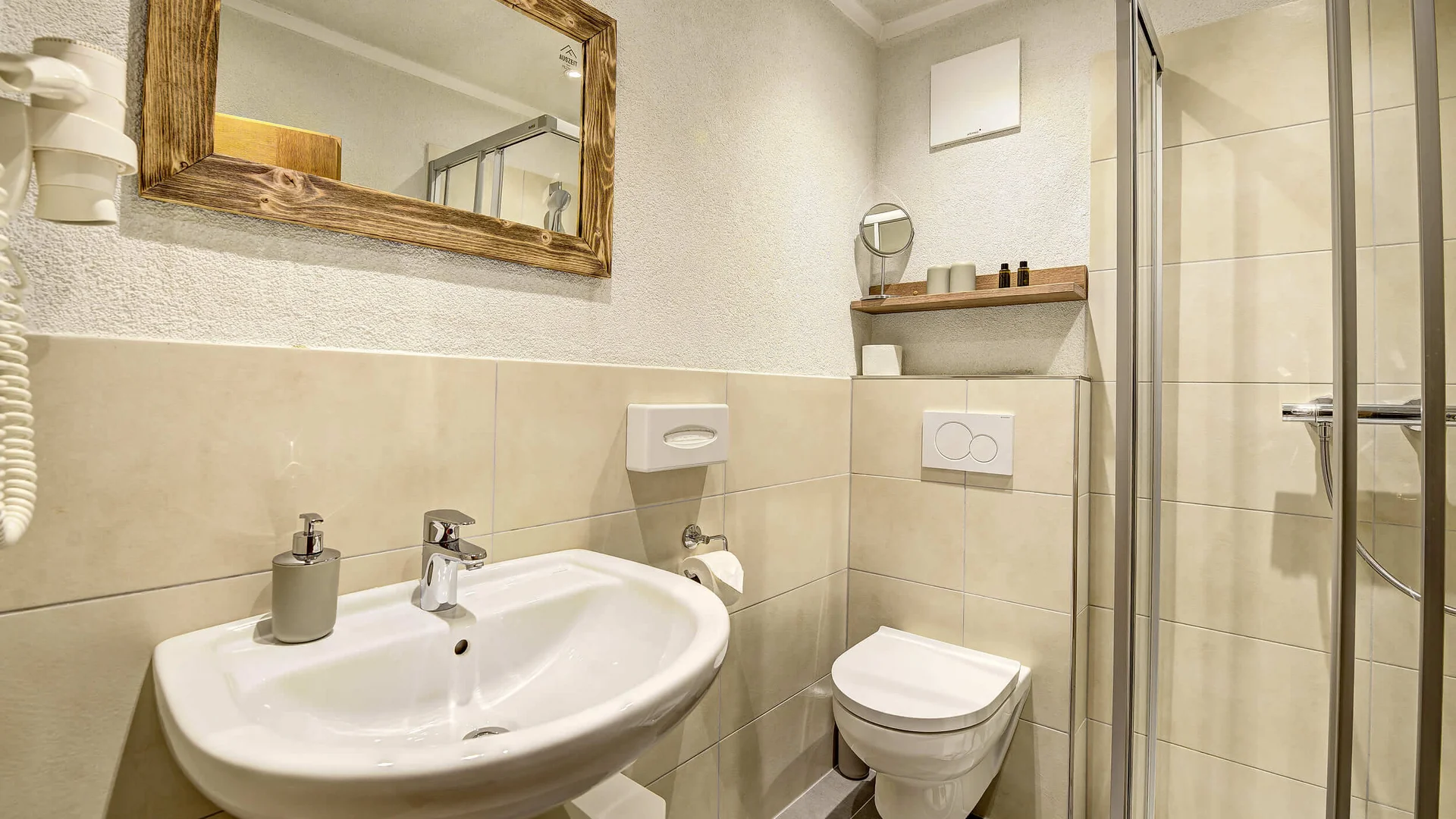 Small modern bathroom with sink, toilet, and shower