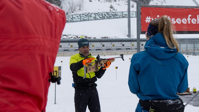Trainer erklärt Biathlon-Schiessen im Schnee an Schießstand