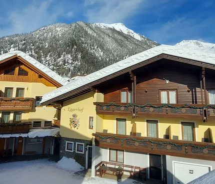 Schneebedeckte Alpenhäuser vor klar blauem Himmel