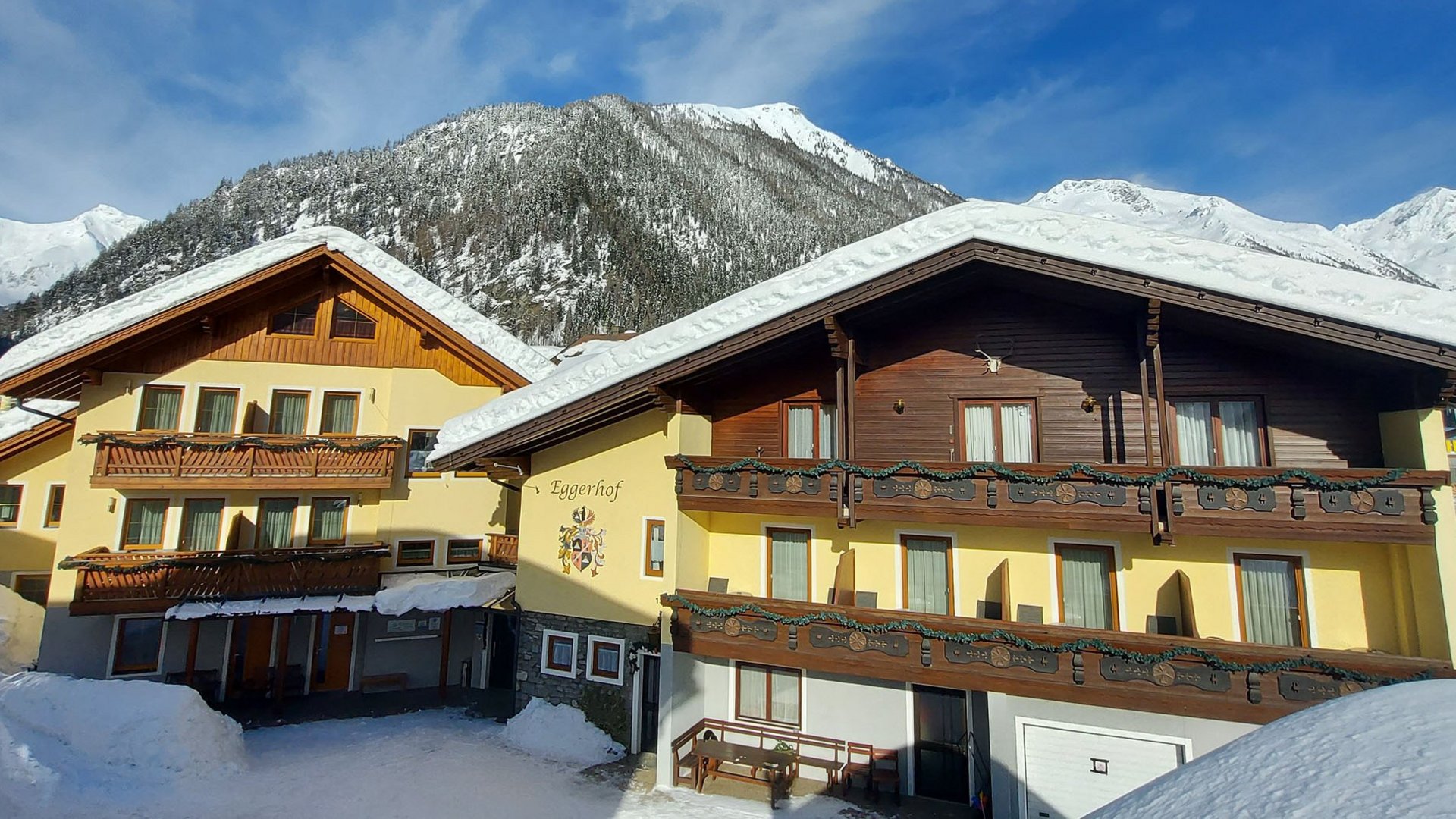 Schneebedeckte Alpenhäuser vor klar blauem Himmel