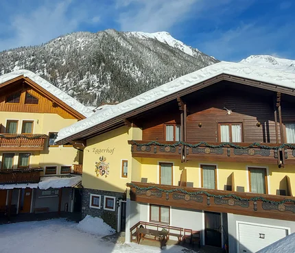 Snow-covered alpine houses under clear blue sky