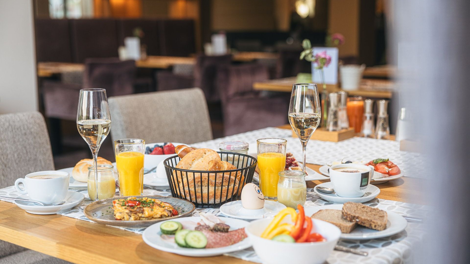 Breakfast table with rolls, eggs, juice, and coffee in a restaurant