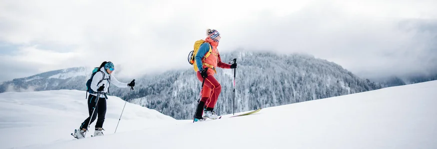 Zwei Skifahrer wandern im Schnee mit Berg im Hintergrund