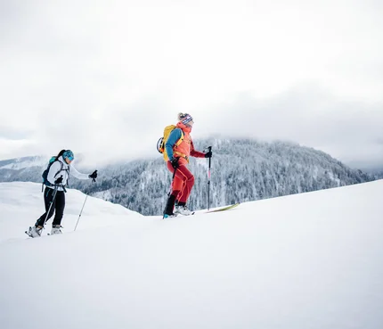 Zwei Skifahrer wandern im Schnee mit Berg im Hintergrund