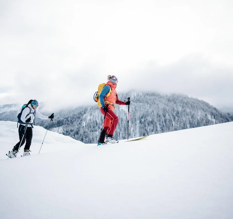 Zwei Skifahrer wandern im Schnee mit Berg im Hintergrund