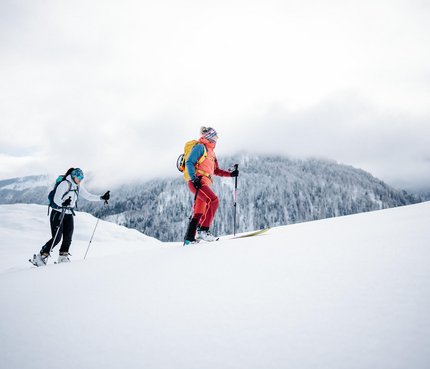 Zwei Skifahrer wandern im Schnee mit Berg im Hintergrund
