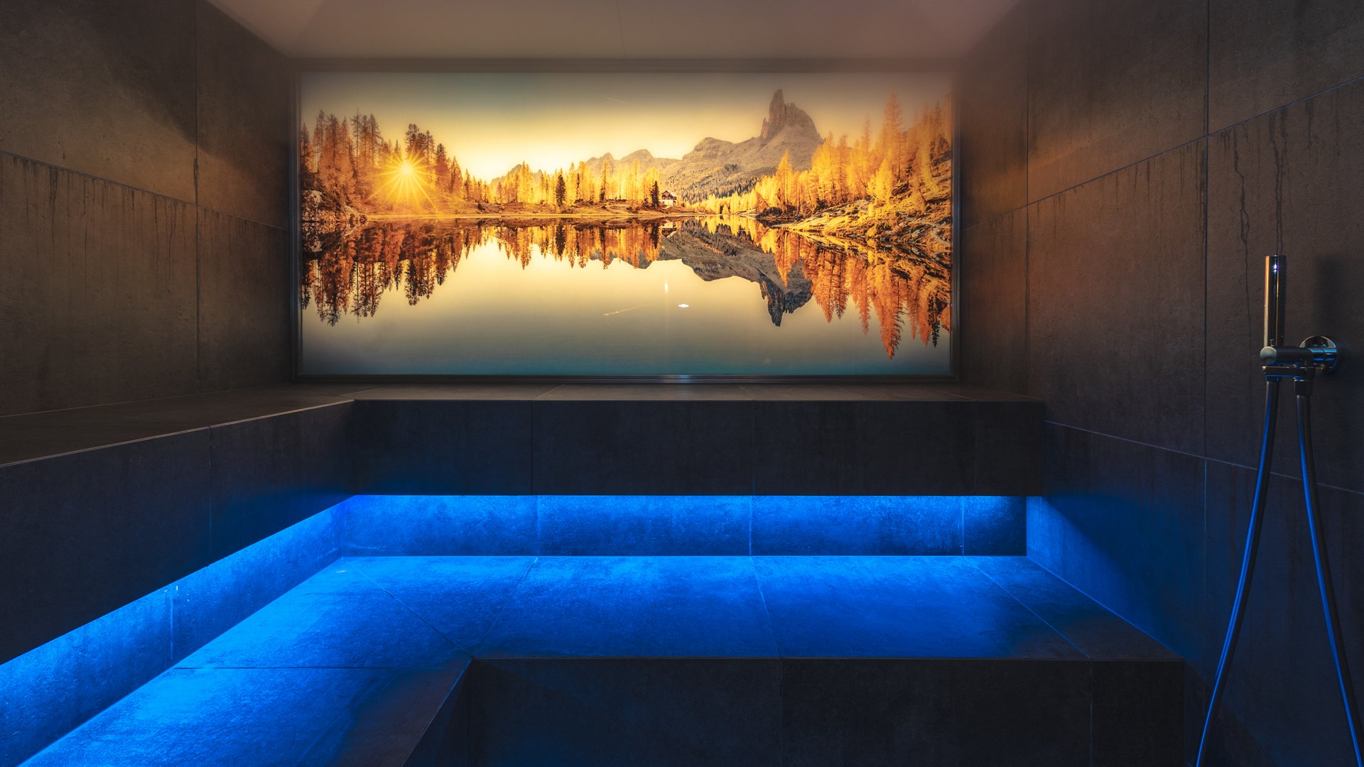 Moderner Spa-Raum mit blauer LED-Beleuchtung und Wandbild eines Bergsees