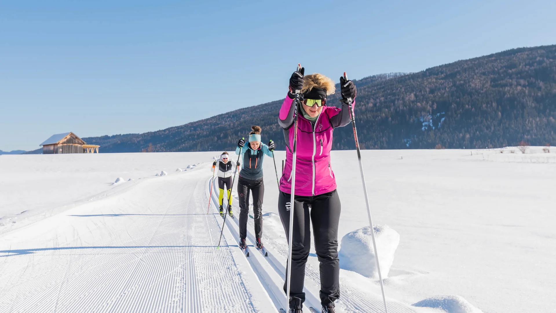 Langlauf Urlaub im Salzburger Lungau © Salzburger Lungau Drei Personen beim Langlaufen auf präparierter Spur im verschneiten Winterland