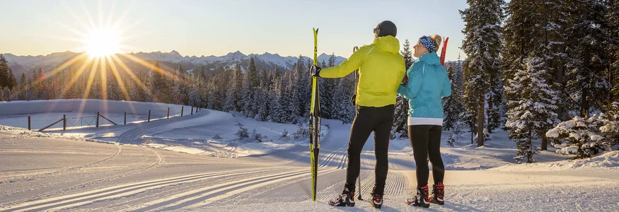 9 Gründe für Langlaufurlaub in Filzmoos © Christian Fischbacher - Filzmoos Tourismus Zwei Skifahrer genießen den Sonnenuntergang in verschneiter Berglandschaft