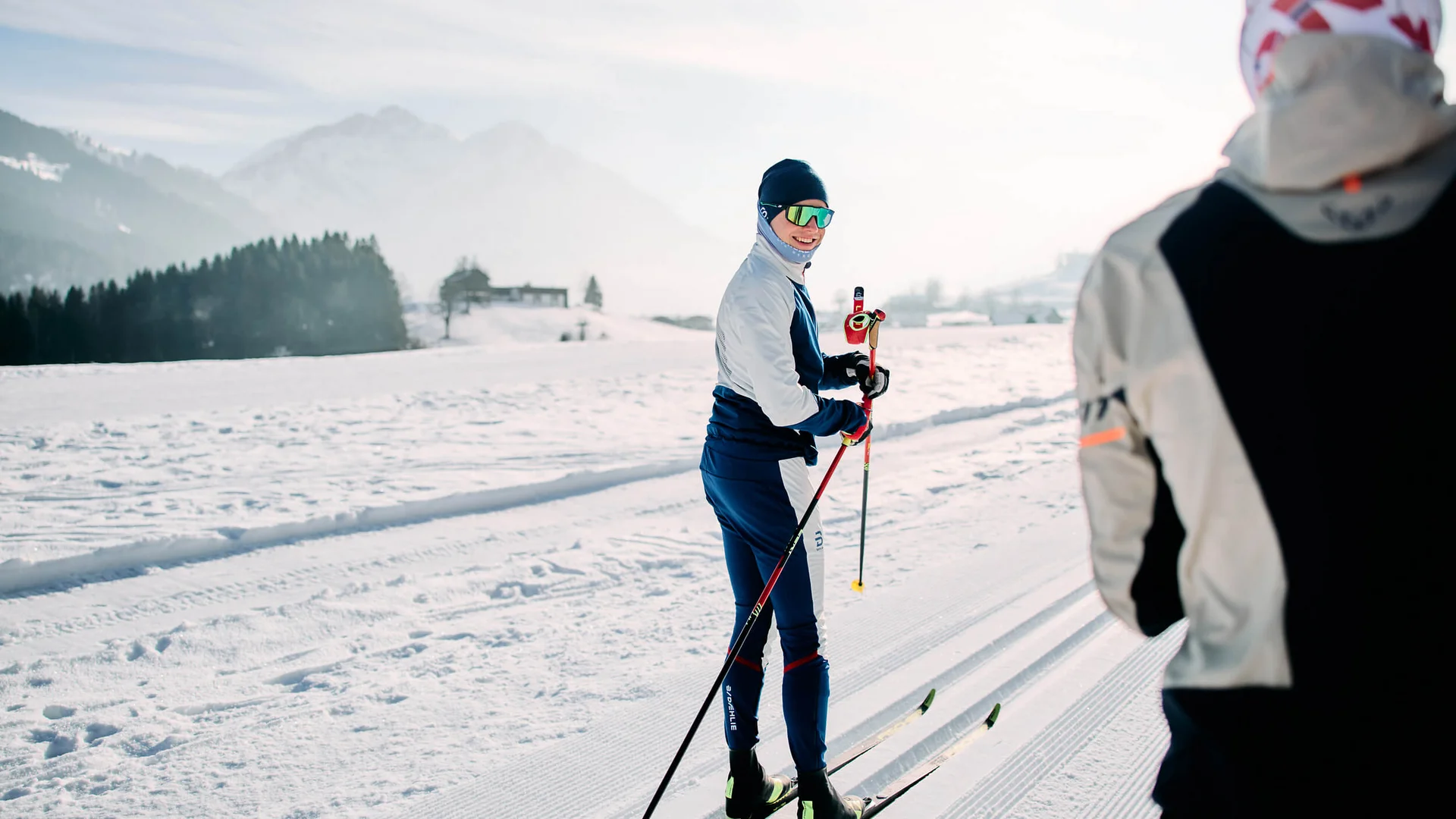 Langlauf Urlaub im Kleinwalsertal © Kleinwalsertal Tourismus - Oliver Farys Zwei Langläufer auf einer verschneiten Loipe vor Bergkulisse
