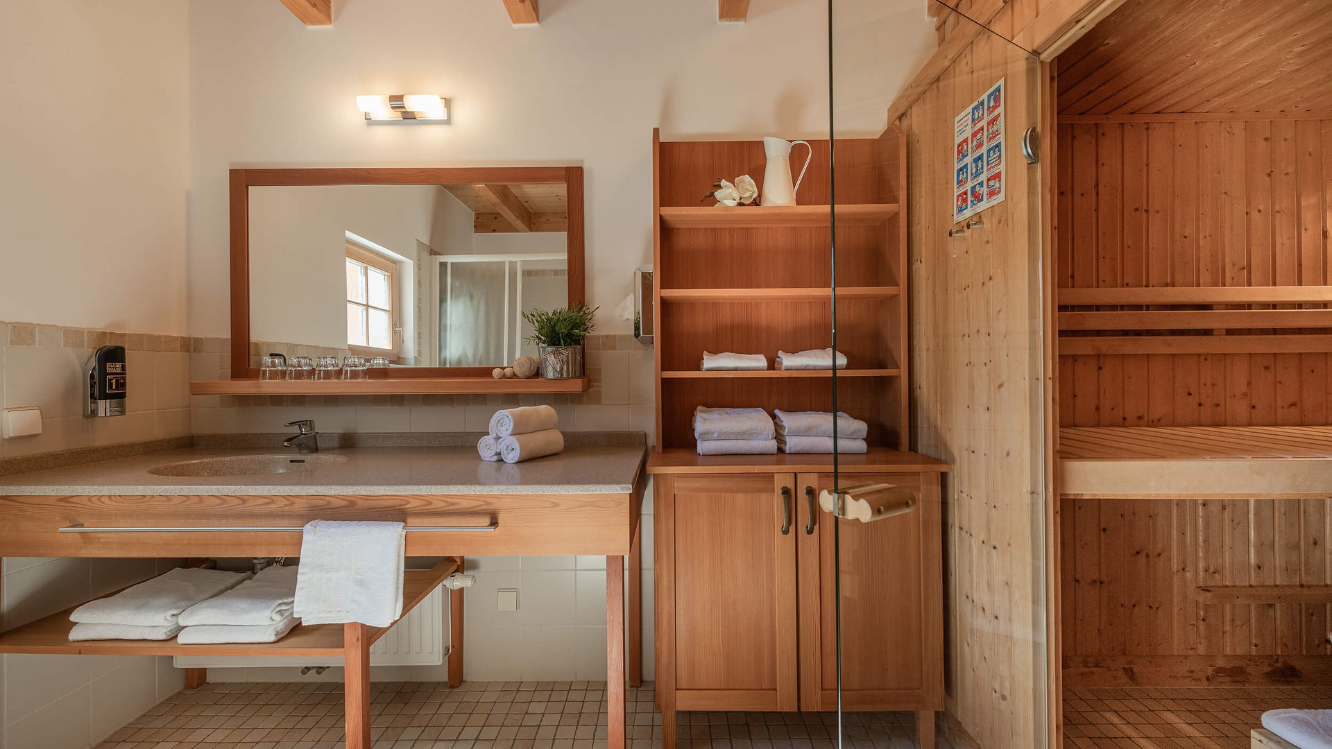 Wood sauna and bathroom with sink and fresh towels