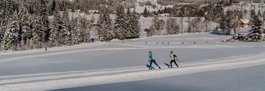 Schladming-Dachstein © TVB Schladming Dachstein - Christine Höflehner Skifahrer auf verschneiter Loipe vor Bergkulisse und Wald