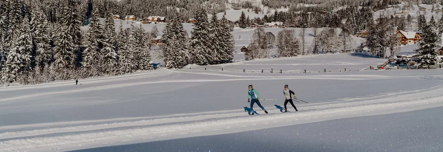Schladming-Dachstein © TVB Schladming Dachstein - Christine Höflehner Skifahrer auf verschneiter Loipe vor Bergkulisse und Wald