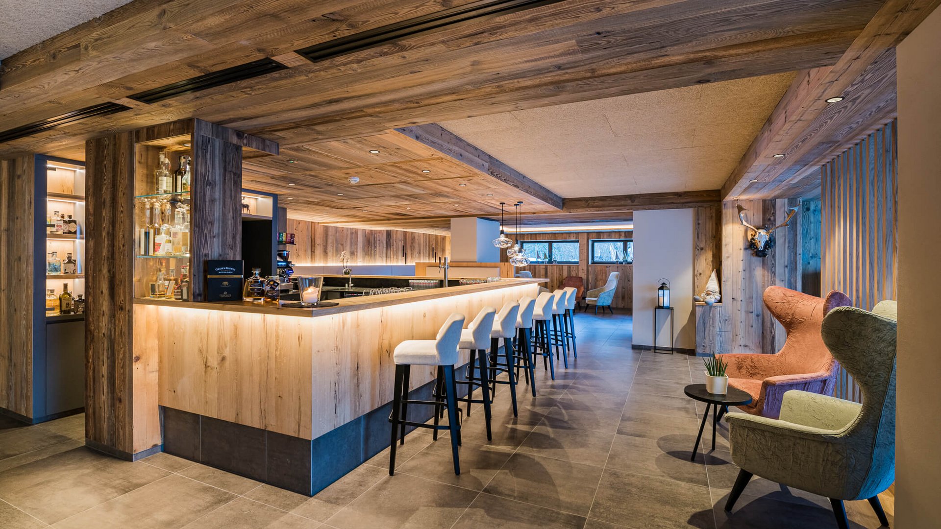 Modern eingerichtete Bar mit Holzvertäfelungen und Stühlen am Tresen