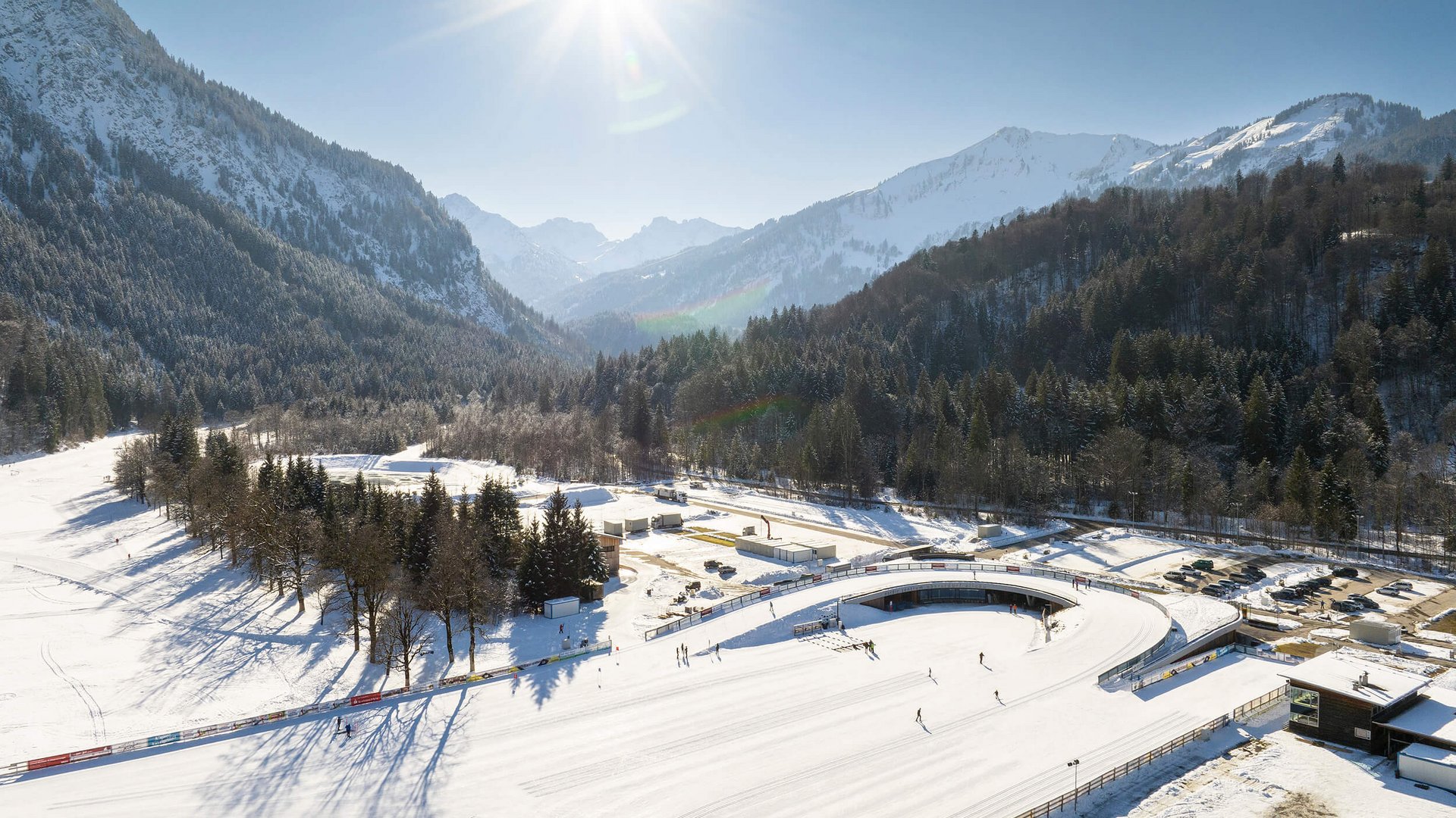 Snowy winter landscape with skiers and sunny sky in the mountains