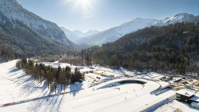 Hobby Biathlon © Tourismus Oberstdorf - Eren Karaman Verschneite Winterlandschaft mit Skifahrern und sonnigem Himmel in den Bergen