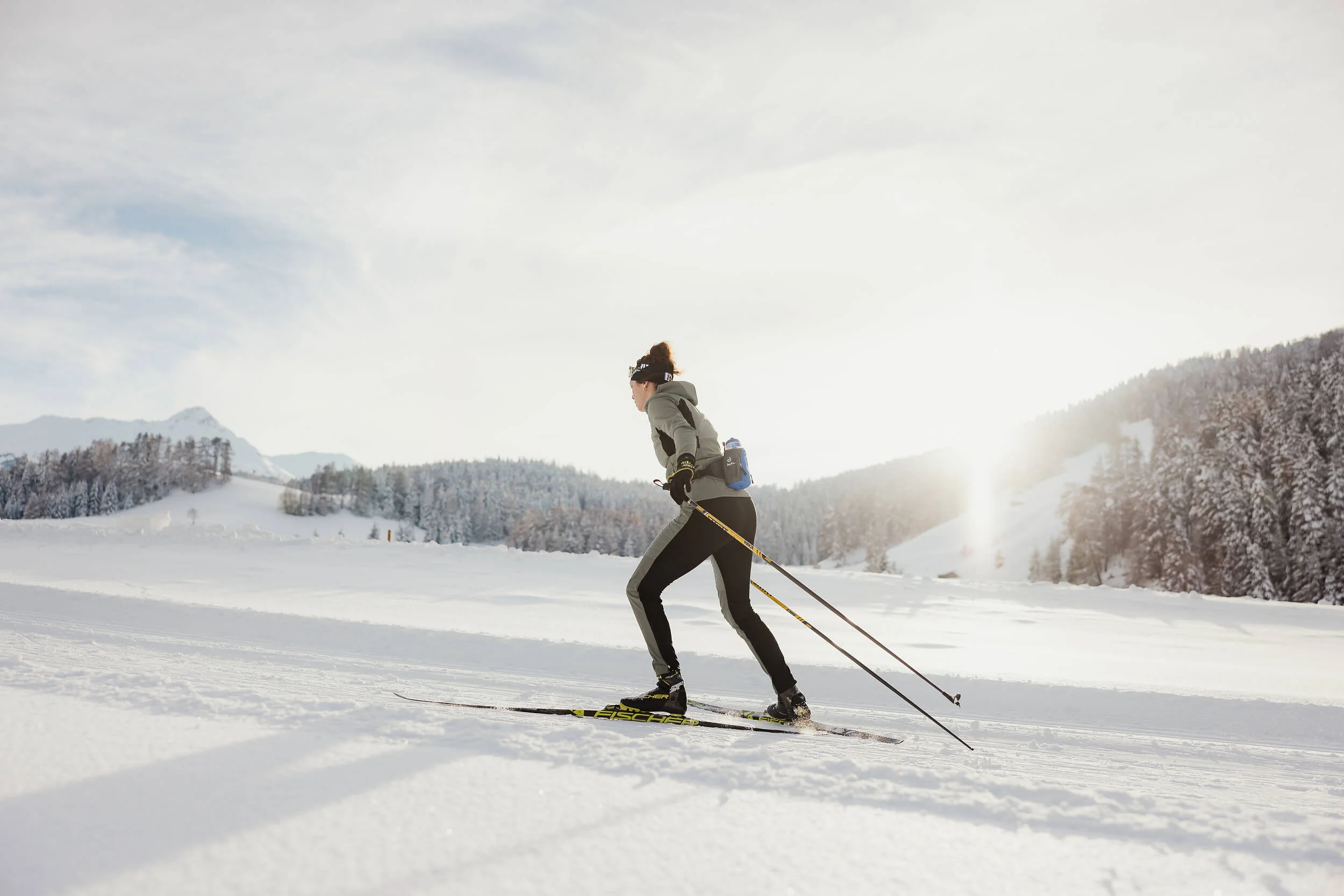 Loipen in Italien © Alex Moling Frau beim Langlaufen auf verschneiter Winterlandschaft bei Sonnenlicht