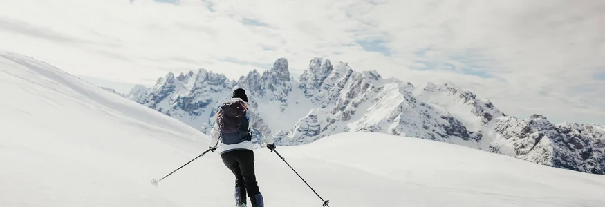 HOW TO SKITOUR © Alex Moling Skifahrer fährt im verschneiten Gebirge mit Bergen im Hintergrund