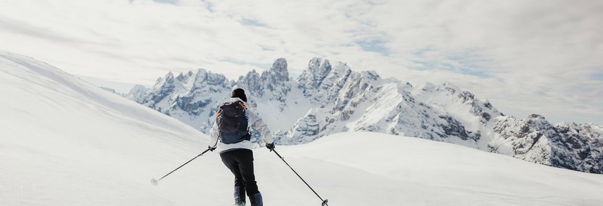 HOW TO SKITOUR © Alex Moling Skifahrer fährt im verschneiten Gebirge mit Bergen im Hintergrund
