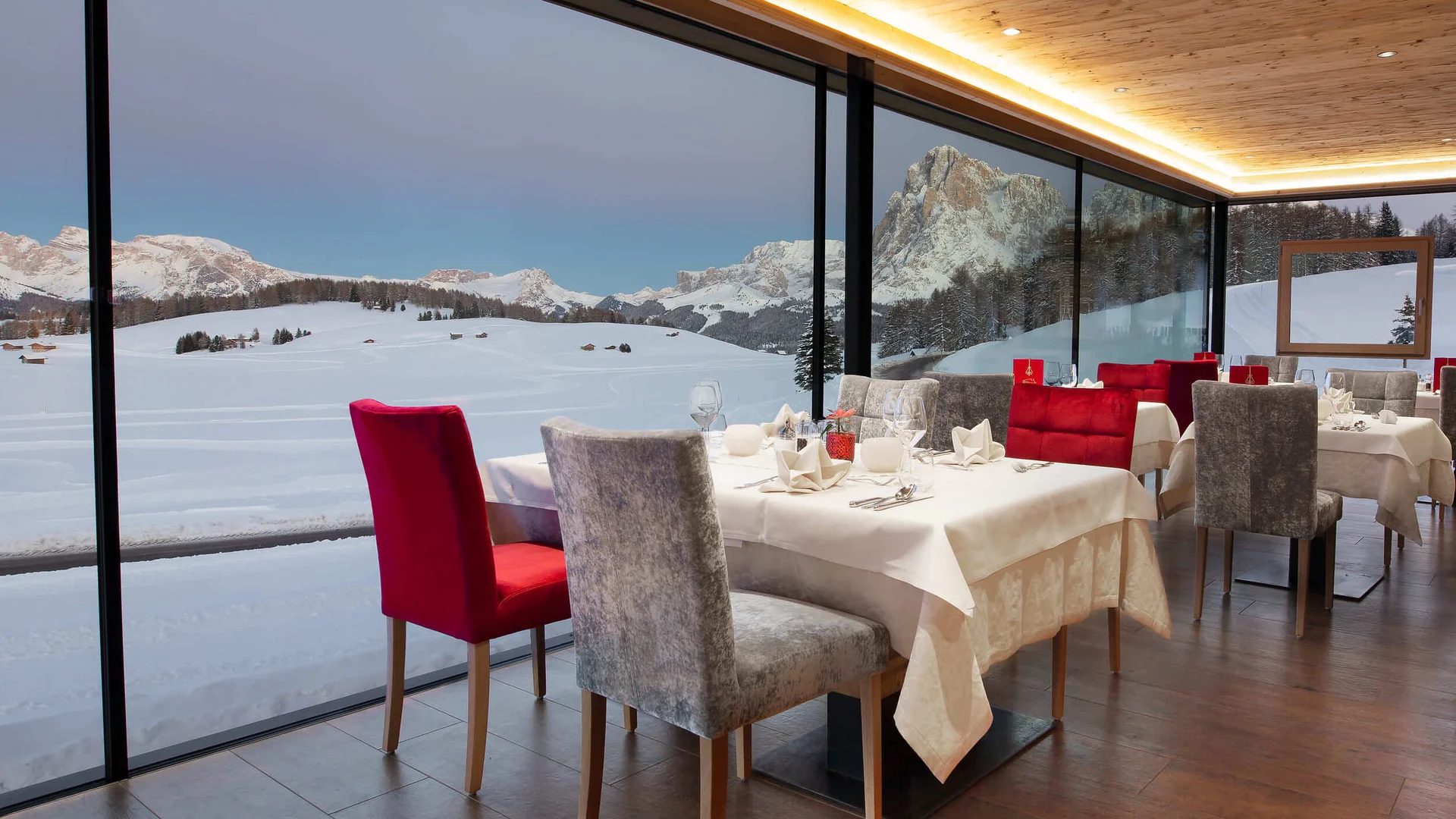 Modern restaurant with panoramic windows overlooking snowy mountains