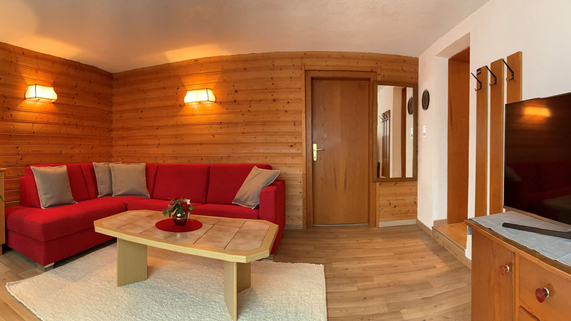 Cozy living room with red corner sofa and wooden paneling