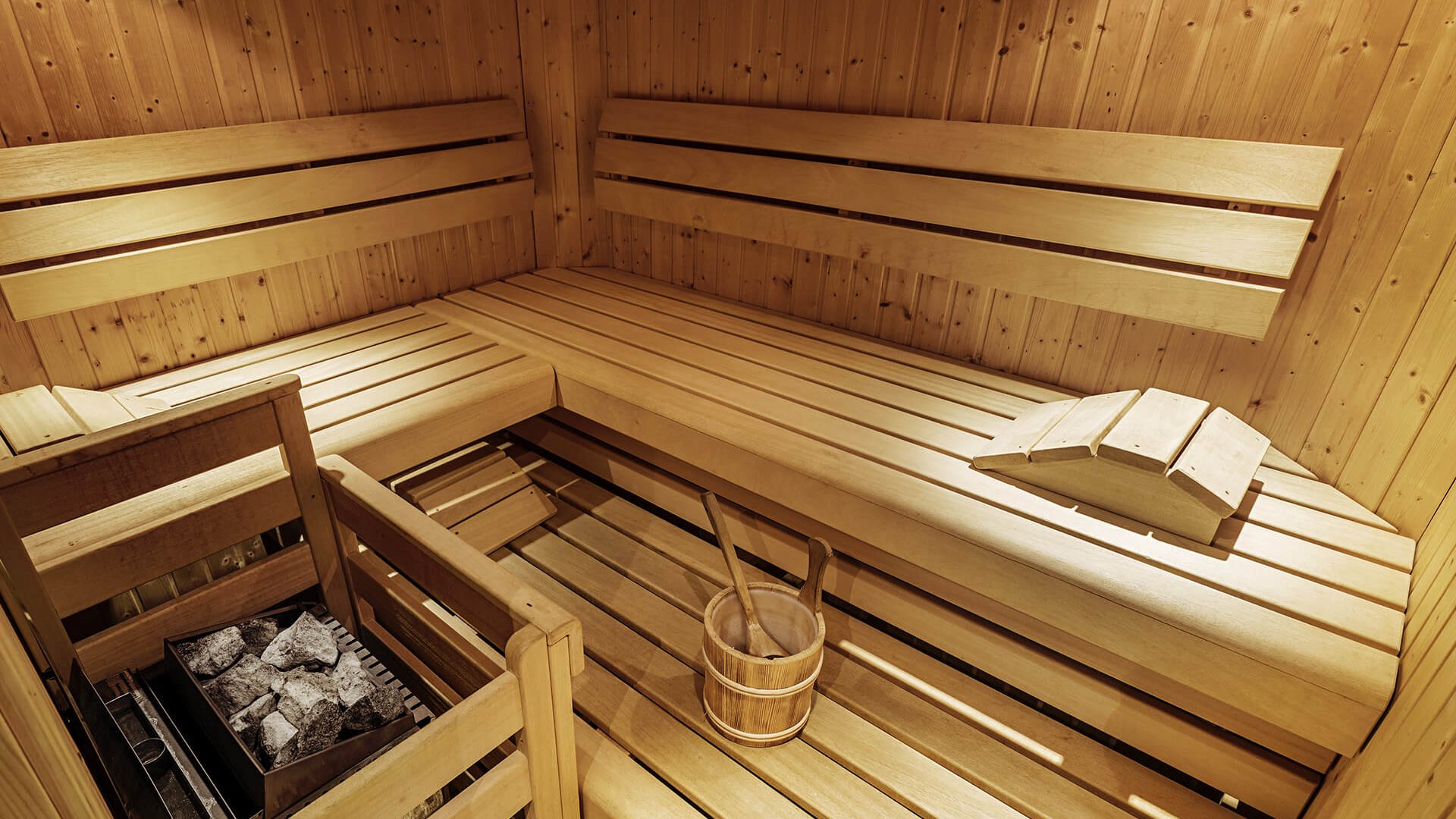 Interior of a wooden Finnish sauna with bench and sauna bucket