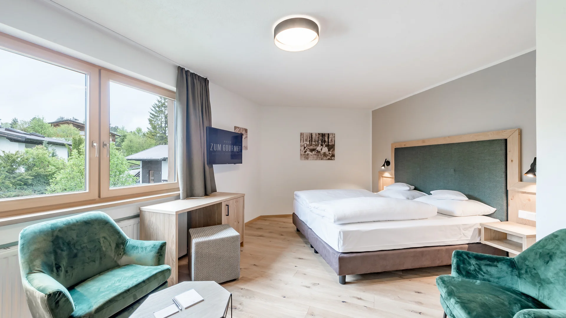 All Inclusive Hotel zum Gourmet **** © Archiv Marcati Hell eingerichtetes Hotelzimmer mit Doppelbett und grünen Sesseln