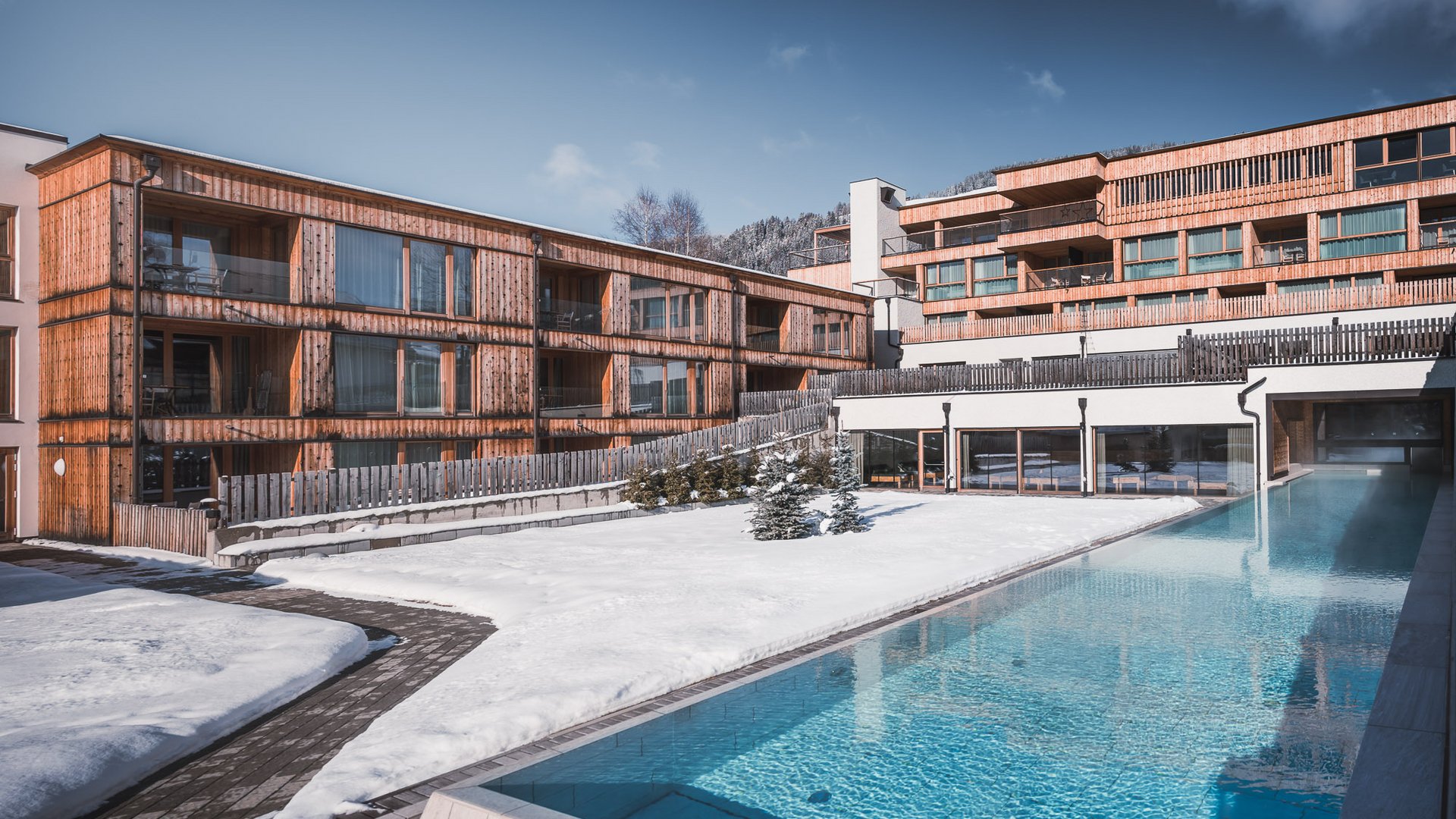 Moderne Holzhäuser mit Pool im winterlichen Schnee