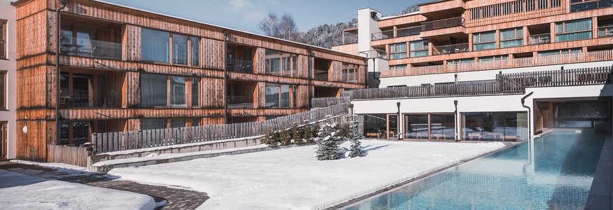 Moderne Holzhäuser mit Pool im winterlichen Schnee